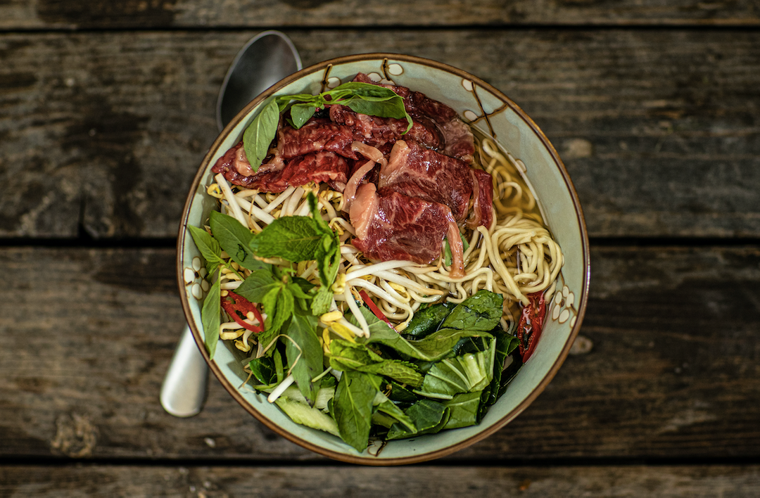 Vietnamese noodle soup with raw wagyu slices and pak choi