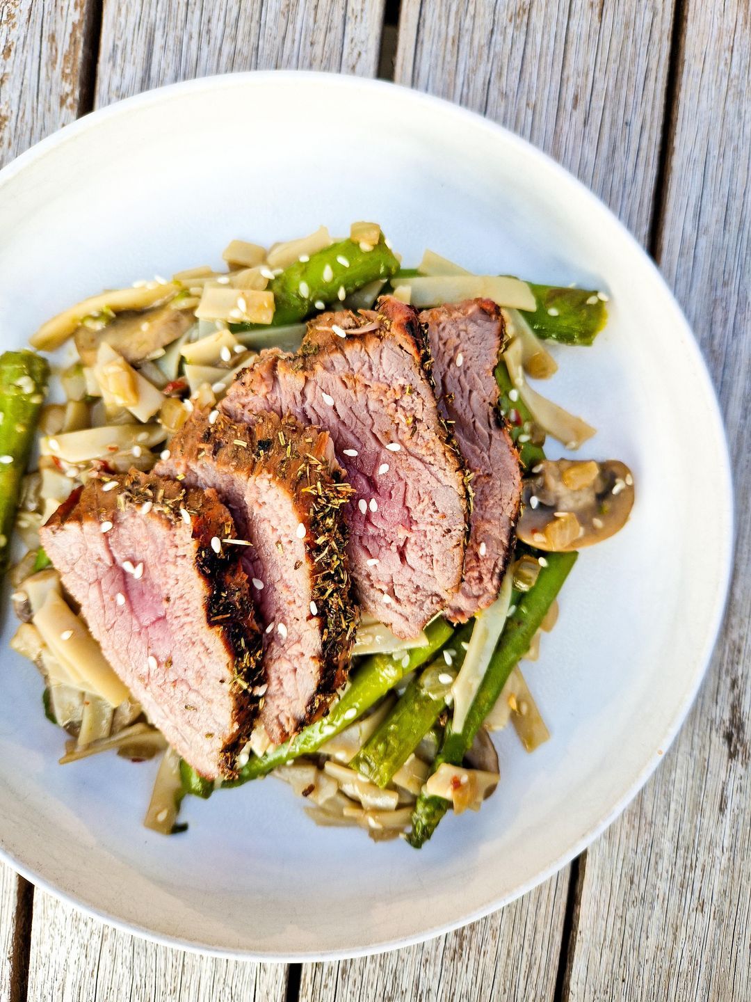 Thai marinated steak with noodles, green asparagus and mushrooms